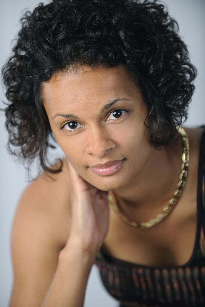 A woman with curly hair and a necklace