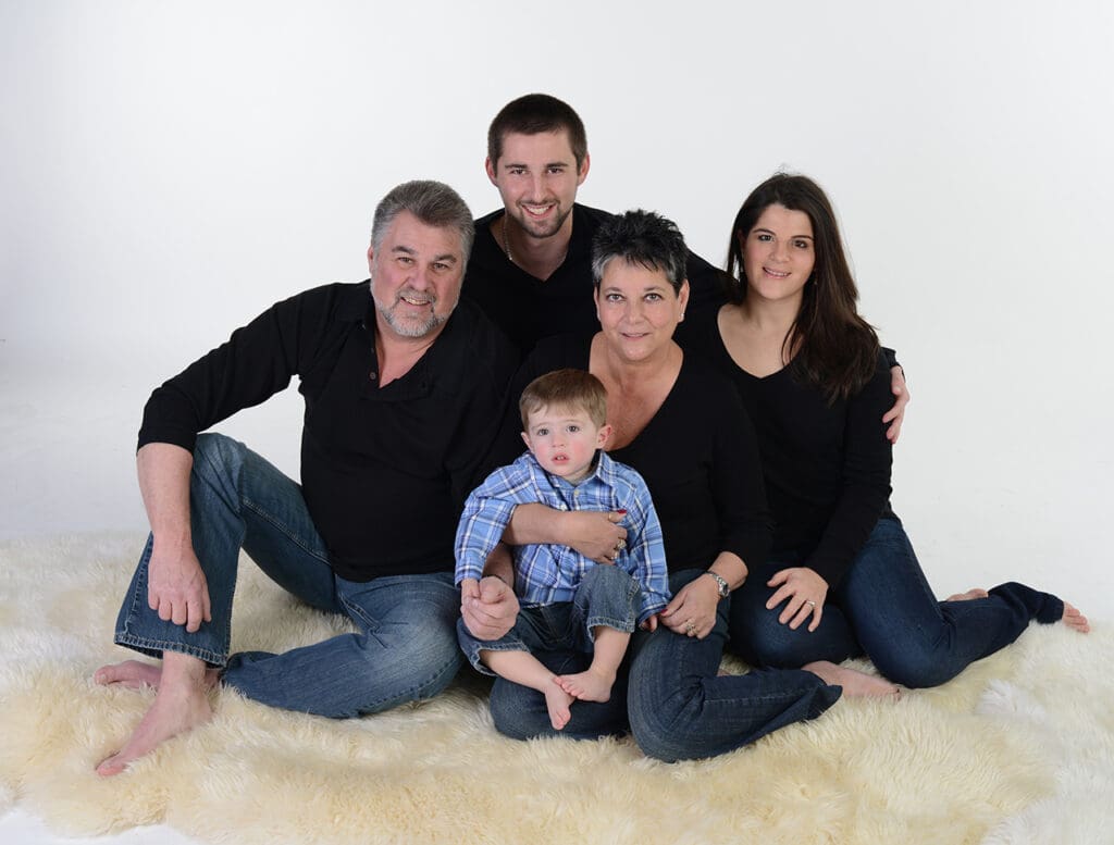 A family posing for a picture in front of the wall