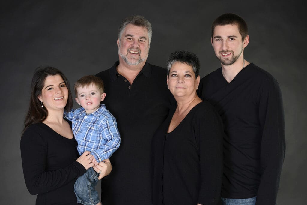 A family posing for a picture in black shirts.