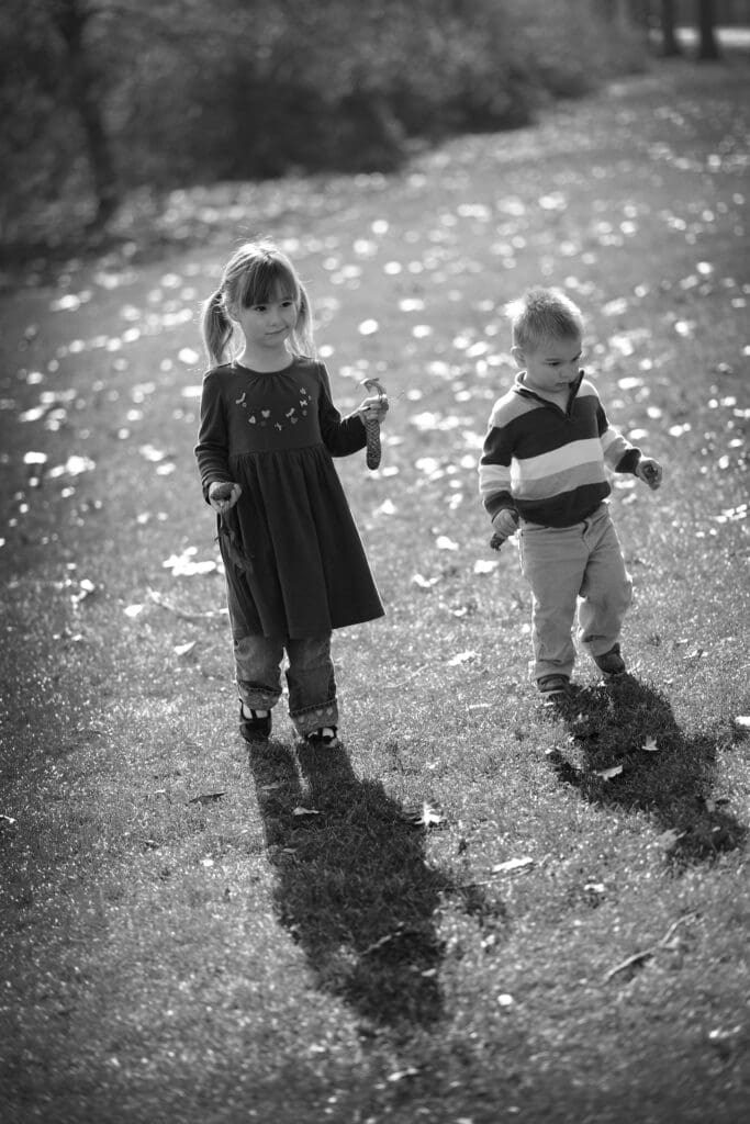 Two children are standing in the rain.