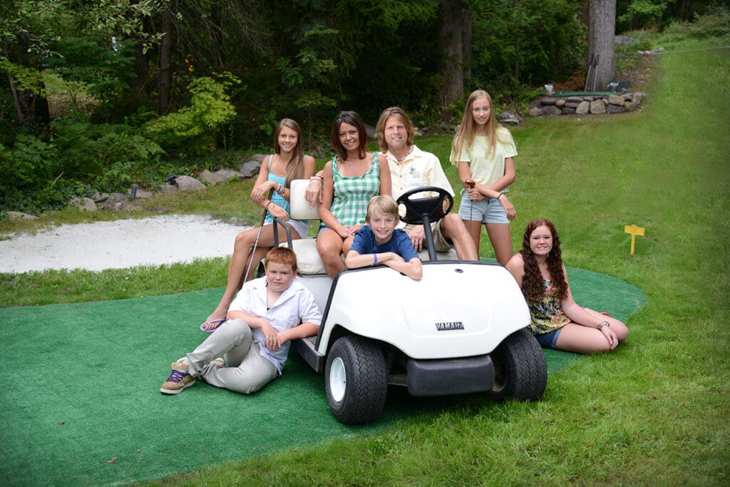 A group of people sitting around a golf cart.